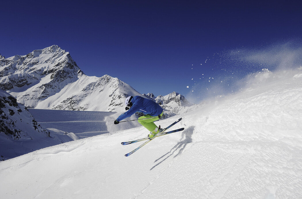 Freerider zeigt im Tiefschnee Sprung-Trick