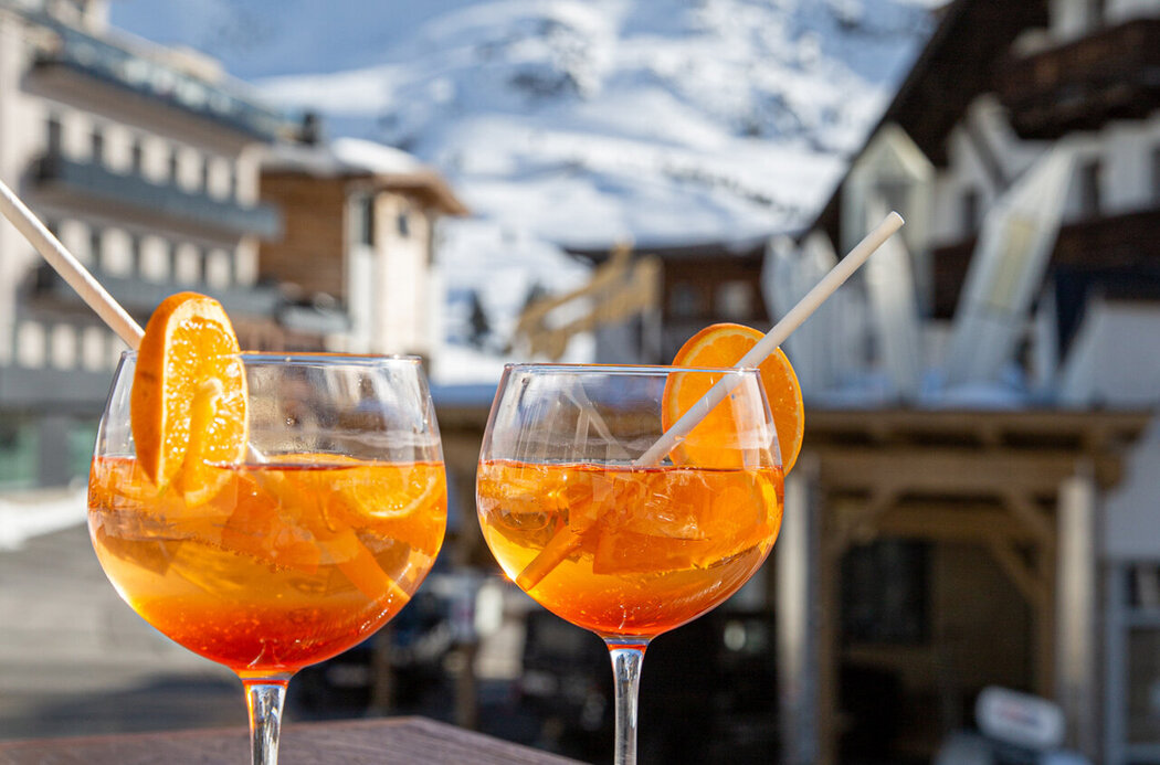 Zwei Gläser Aperol vor Bergpanorama