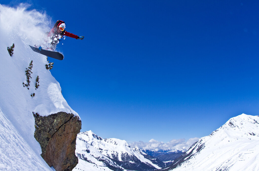 Snowboarder fährt im freien, felsigen Gelände