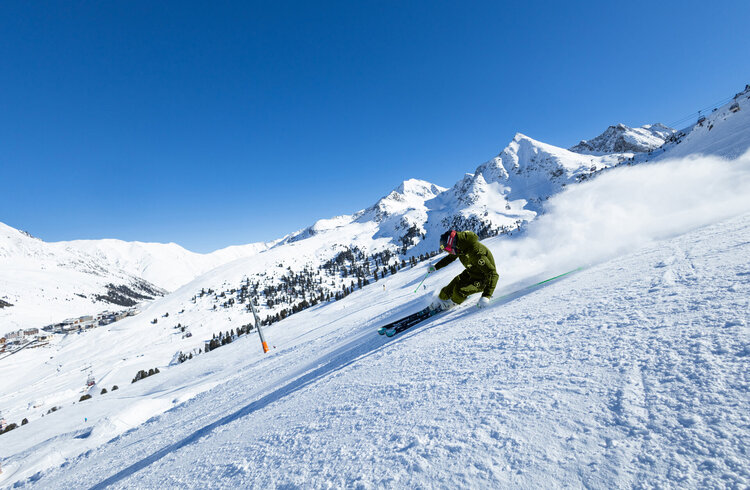 Skifahrer bei der Abfahrt im steilen Gelände