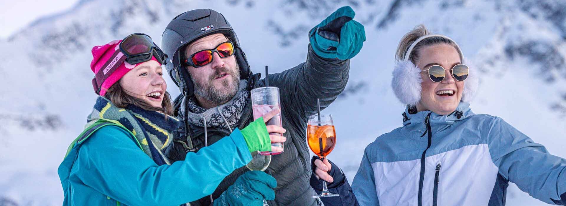 3 Personen vor verschneitem Gipfelpanorama